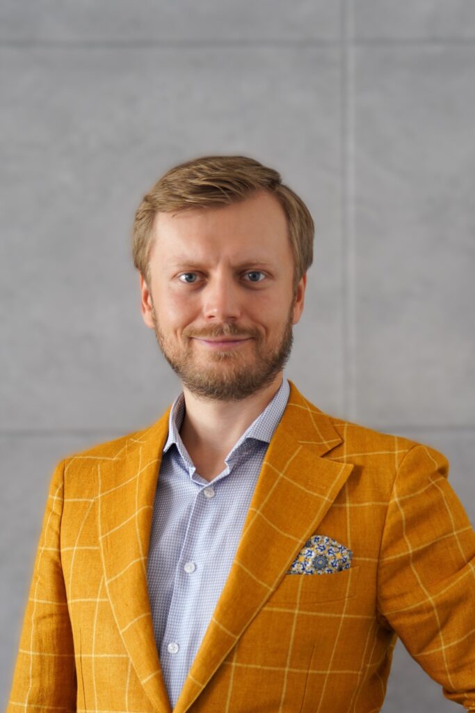 młody mężczyzna uśmiechnięty w marynarce